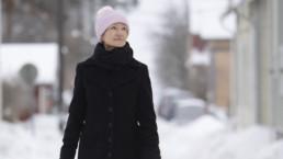 Sirkku Peltola kävelee talvisella kadulla Tampereen Pispalassa