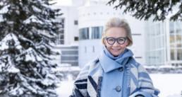 Nainen Tampere-talon edustalla sinisissä silmälaseissa