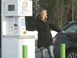 Nainen tankkaa biokaasua autoonsa tankkausasemalla